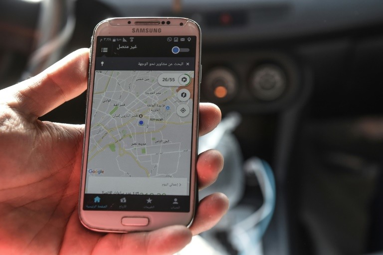 سائق سيارة اجرة يعمل لدى اوبر يعرض خارطة على هاتفه النقال في 19 ابريل.